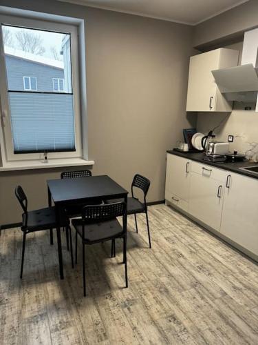 een keuken met een tafel en stoelen in een kamer bij Raina 28 apartment in Madona