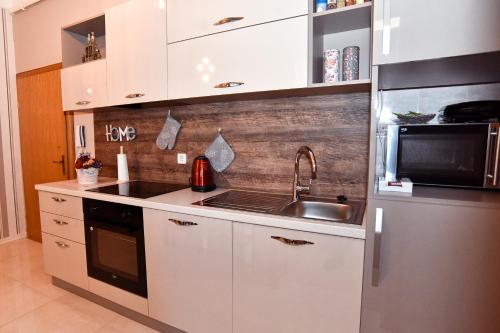 a kitchen with a sink and a refrigerator at Apartman Podravina in Ludbreg