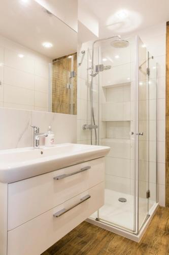 a white bathroom with a sink and a shower at Zakopane Śnieżna Przełęcz in Zakopane