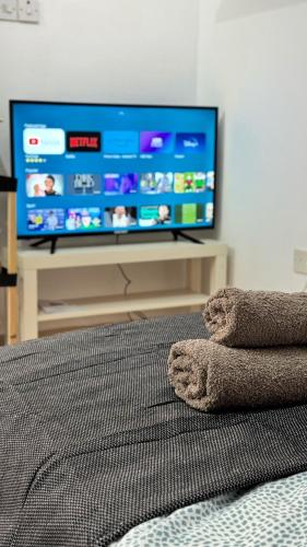 a bedroom with a flat screen tv and a bed at PMP Adamia Apartments in Peyia
