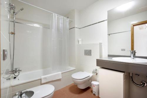 a white bathroom with a toilet and a sink at Casa Rosi 1 in Puerto del Rosario