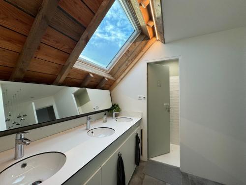a bathroom with two sinks and a large window at LES BRIQUES in Lion-sur-Mer