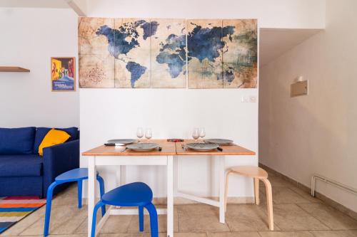 une table avec deux chaises et une carte sur le mur dans l'établissement Le Cerisier des 4 Chemins - Appt 75m² pour 6, à Carcassonne