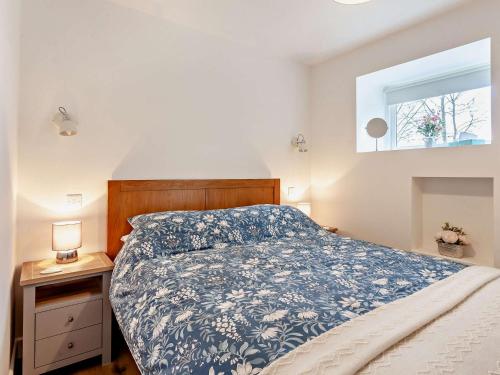 1 Bed in Wotton-under-Edge 91936 في ووتون أندر إيدج: غرفة نوم بسرير ولحاف ابيض و ازرق