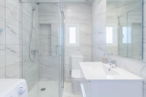 baño blanco con ducha y lavamanos en BRAND NEW PENTHOUSE TERRACE BBQ WIFI MODERN MALAGA en Málaga