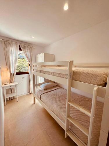 a bedroom with two bunk beds and a window at Amber Holiday Home in Peniscola