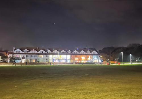 a building at night with a field in front of it at Cambria Hotel in Paignton