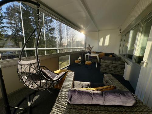 Exotisk lägenhet/ Friparkering في فاستيراس: شرفة مع أرجوحة وغرفة معيشة