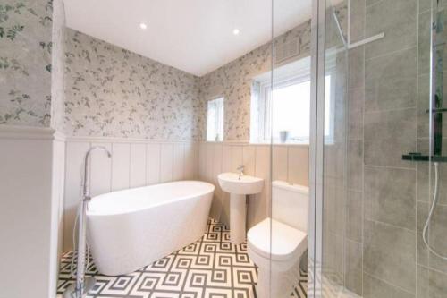 a bathroom with a tub and a toilet and a sink at Recently refurbished home. in Poulton le Fylde