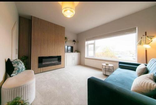 a living room with a blue couch and a fireplace at Beautifully styled Home with Garden in Poulton le Fylde