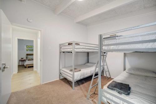 1 Schlafzimmer mit 2 Etagenbetten und einem Flur in der Unterkunft Vibrant House w Great Backyard Pool and Jacuzzi in Irving