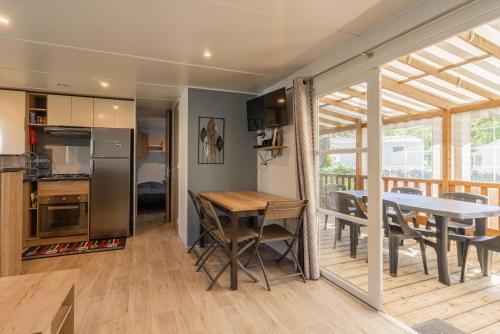 une cuisine et une salle à manger avec une table et des chaises dans l'établissement Mh 169 Ronce les bains, à La Tremblade