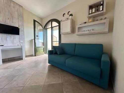 un sofá azul en la sala de estar con TV en La Casetta di Lia - vista mare Eden Rock, en Riva dei Pini