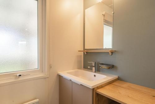 une salle de bain avec un lavabo et un miroir dans l'établissement Mh 169 Ronce les bains, à La Tremblade