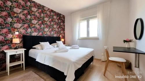 ein Schlafzimmer mit einem Bett mit einer Blumenwand in der Unterkunft Apartment Perlita in Fažana