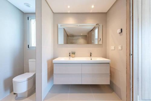 ein Badezimmer mit einem weißen Waschbecken und einem WC in der Unterkunft LUXURY PENTHOUSE MARBELLA WIFI POOLS NETFLIX GOLF in Benahavís