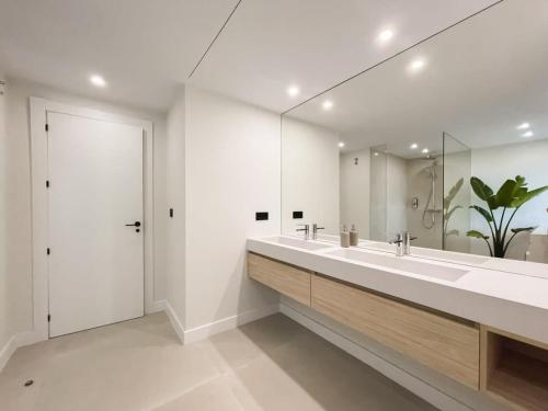 een badkamer met 2 wastafels en een grote spiegel bij HEATED ROOFTOP POOL PENTHOUSE VIEWS MAGNA MARBELLA in Marbella