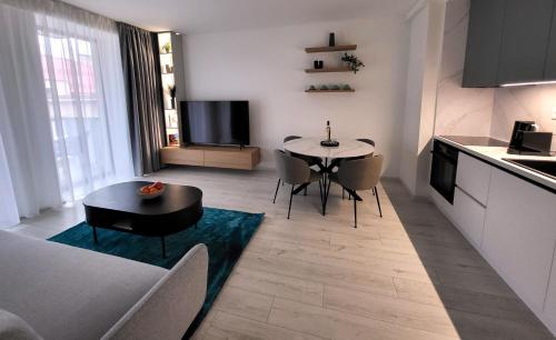 a kitchen and a living room with a table and chairs at Apartment EDIAS ONE in Banská Bystrica