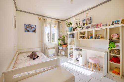 une chambre d'enfant avec un lit et un tabouret dans l'établissement Villa 6 pers avec piscine, à Le Tignet