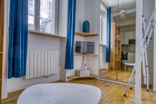 Cette chambre dispose de rideaux bleus et d'un miroir. dans l'établissement Nemo, Studio avec mezzanine sur cour Porte Maillot, à Paris