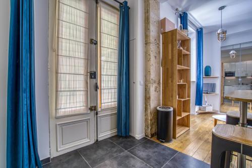 Cette chambre dispose de rideaux bleus et d'une porte. dans l'établissement Nemo, Studio avec mezzanine sur cour Porte Maillot, à Paris