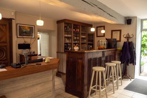 - un bar dans un restaurant avec tabourets dans une pièce dans l'établissement Logis Hôtel Le Manoir Des Portes, à Lamballe