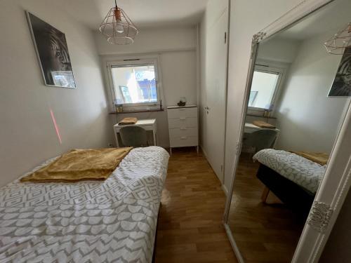 a bedroom with a bed and a mirror at Exotisk lägenhet/ Friparkering in Västerås