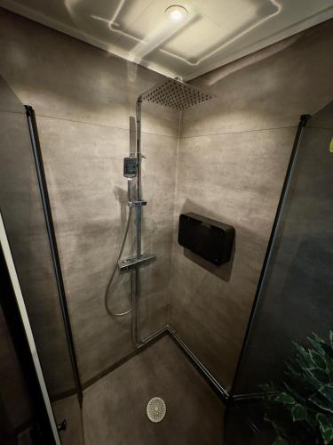 a shower stall with a television in a bathroom at Exotisk lägenhet/ Friparkering in Västerås