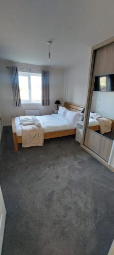 a large bedroom with two beds and a large mirror at Guest Village in Hull