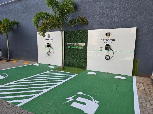 un suelo verde con una palmera en el medio en Hotel Metrópole Maringá, en Maringá