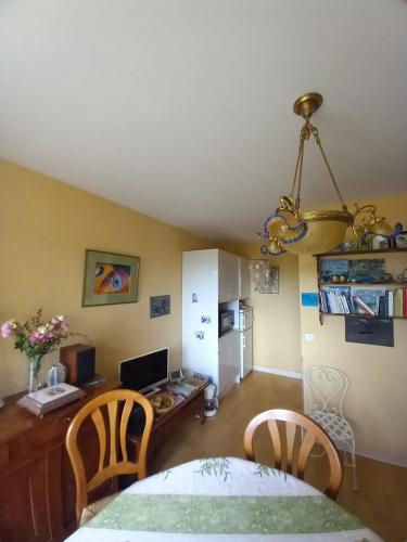 d'une salle à manger avec une table, des chaises et un bureau. dans l'établissement Appartement charmant avec vue sur la mer à Cabourg - 30 m², à Cabourg