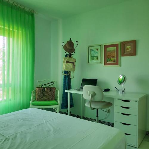 a bedroom with a bed and a desk and a chair at LAS MIMOSAS PARADISE in La Cala de Mijas