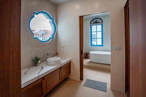 a bathroom with a sink and a tub and a mirror at Spacious 6BR Villa Near Beach in Ha Long