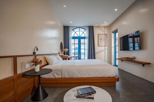 a bedroom with a bed and a table with a book on it at Spacious 6BR Villa Near Beach in Ha Long