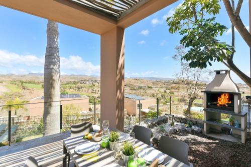 un patio con chimenea, mesa y sillas en Los Lagos 37 by VillaGranCanaria, en Las Palmas de Gran Canaria