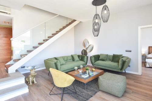 una sala de estar con 2 sofás verdes y una mesa. en Los Lagos 37 by VillaGranCanaria, en Las Palmas de Gran Canaria
