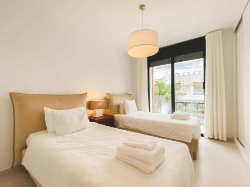 - 2 lits blancs dans une chambre avec fenêtre dans l'établissement Duplex 3 Bedrooms Wifi Pools Jacuzzi, à Estepona