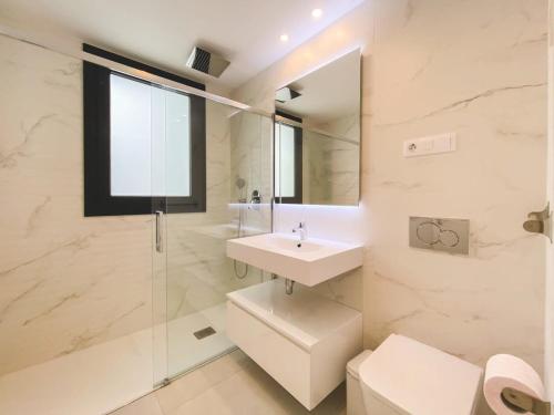 La salle de bains est pourvue d'un lavabo, de toilettes et d'un miroir. dans l'établissement Duplex 3 Bedrooms Wifi Pools Jacuzzi, à Estepona