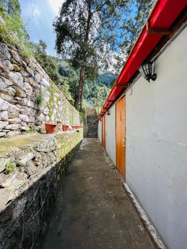 a stone wall with a pathway next to a building at Peace space resort in Nainital