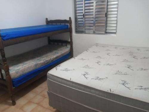 een slaapkamer met 2 stapelbedden en een raam bij Condomínio Villagio Maranduba - Apenas 5 min á pé da praia - Bl 7 in Ubatuba