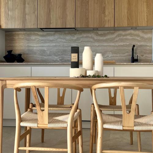 une cuisine avec une table en bois et deux chaises dans l'établissement Quintessenza Casa in Ajaccio, à Ajaccio