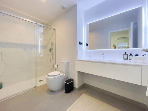 La salle de bains est pourvue d'une douche, de toilettes et d'un lavabo. dans l'établissement New luxury apartment in family resort w pools wifi, à Estepona
