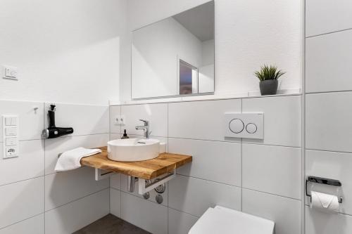 ein weißes Bad mit einem Waschbecken und einem WC in der Unterkunft Km Style Apartments 8 in Freiburg im Breisgau