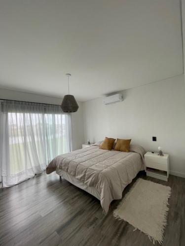 biała sypialnia z dużym łóżkiem i dywanem w obiekcie Casa familiar a la laguna en San Sebastian, Escobar, 3 dormitorios, jardín, pileta y parrilla w mieście Zelaya