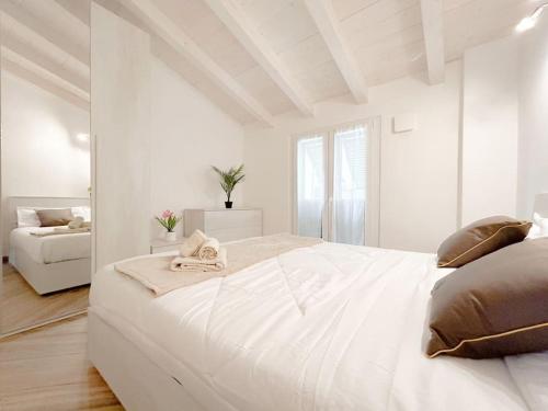ein weißes Schlafzimmer mit einem großen weißen Bett und einem Sofa in der Unterkunft [Elegante Suite] Via Sestri - Airport - WiFi in Genua