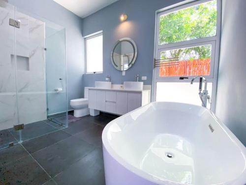 bagno con vasca, lavandino e specchio di Big 5BR Home for an epic time in Riviera Maya ad Akumal