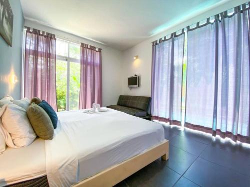 1 dormitorio con 1 cama blanca grande y ventanas en Big 5BR Home for an epic time in Riviera Maya en Akumal