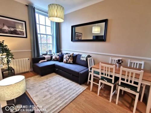 een woonkamer met een blauwe bank en een tafel bij CENTRAL LOCATION 2 BED APT Fast WIFI & TV&KITCHEN in Dublin