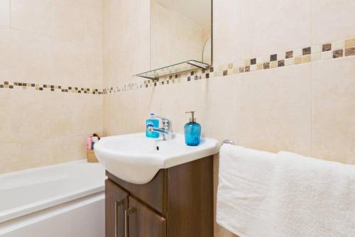 een badkamer met een witte wastafel en een bad bij CENTRAL LOCATION 2 BED APT Fast WIFI & TV&KITCHEN in Dublin
