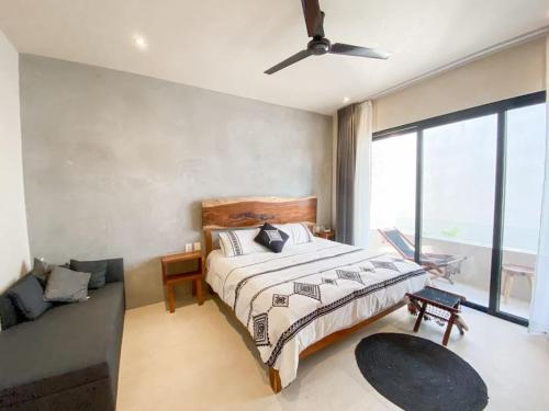 een slaapkamer met een groot bed en een bank bij BohoChic Studio with Full Kitchen, Pool, Balcony WiFi in Tulum
